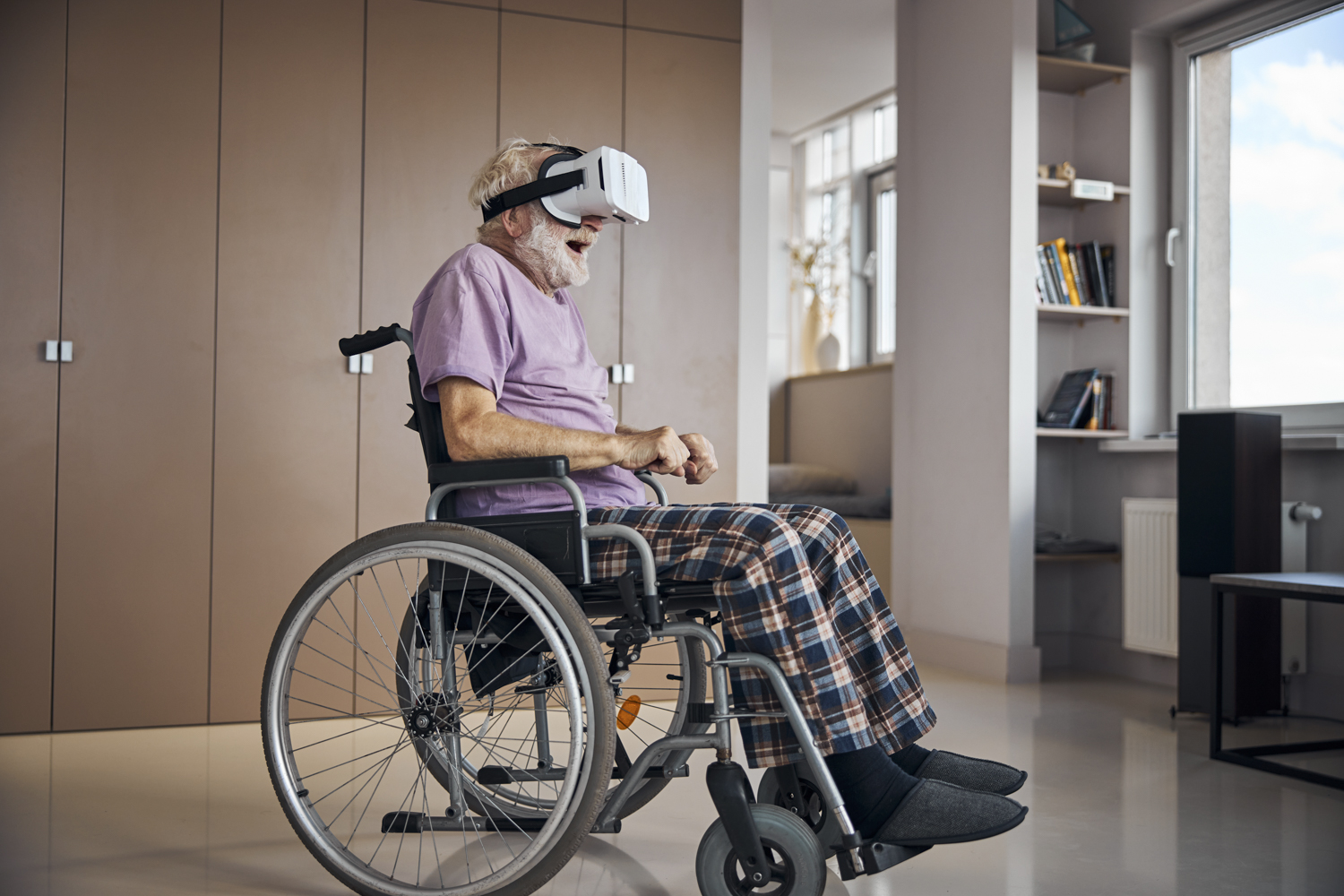 En gammal man i rullstol använder VR glasögon