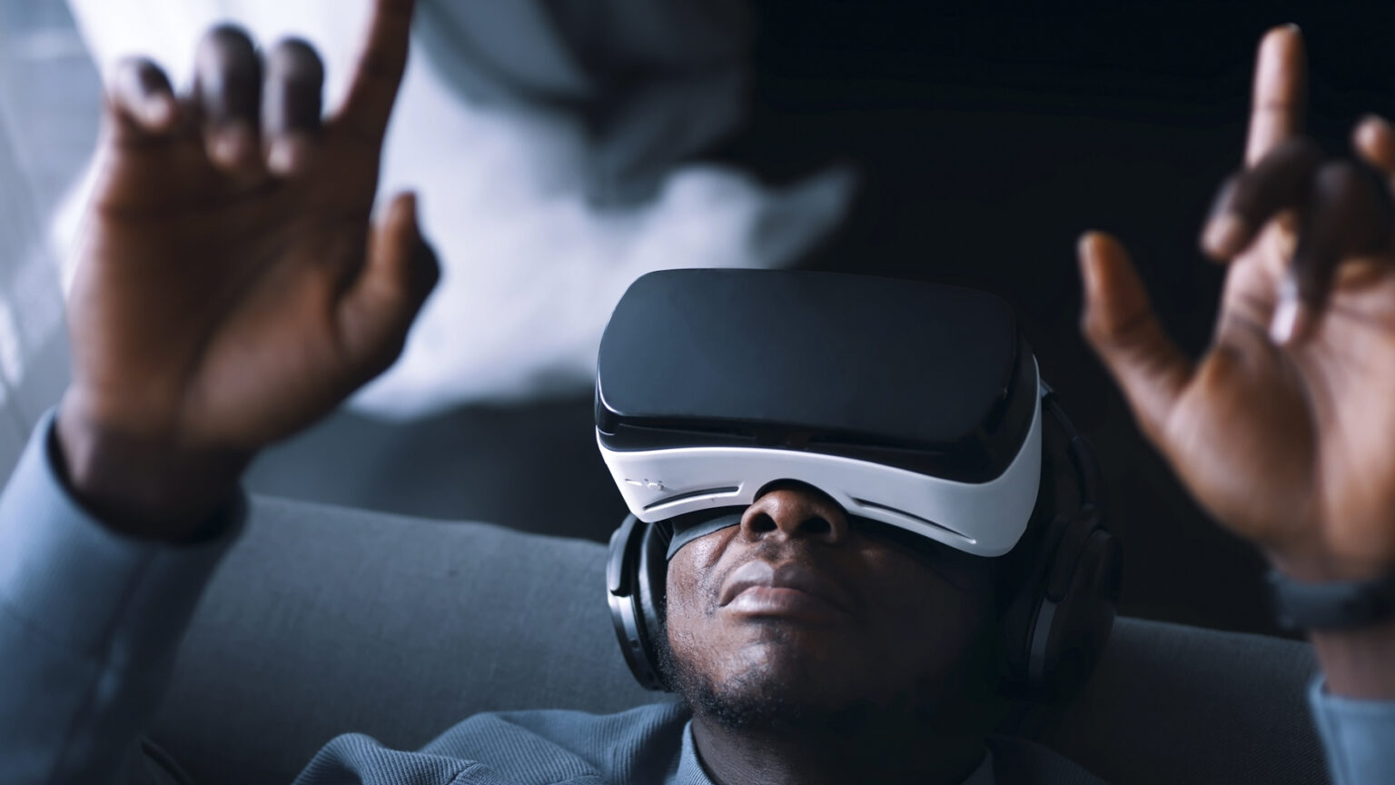 man sitter på en soffa och använder VR-glasögon.