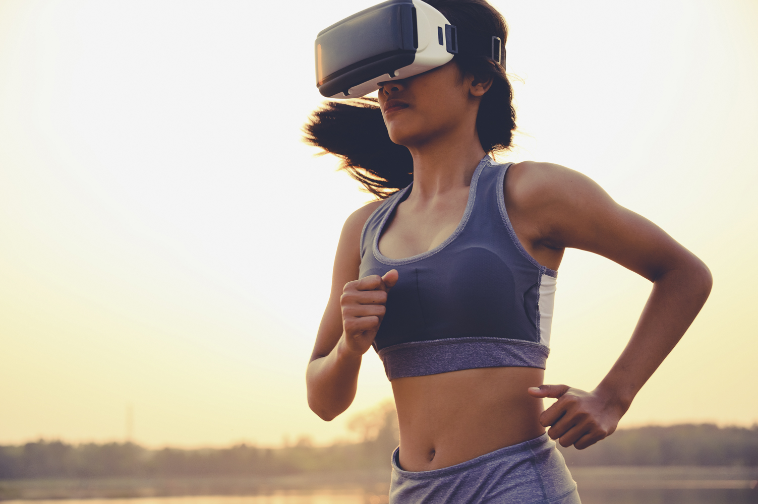 En kvinna springer på stranden och tränar med VR