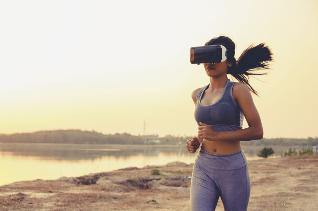 Träning med VR - En kvinna springer på en strand när solen går ned.