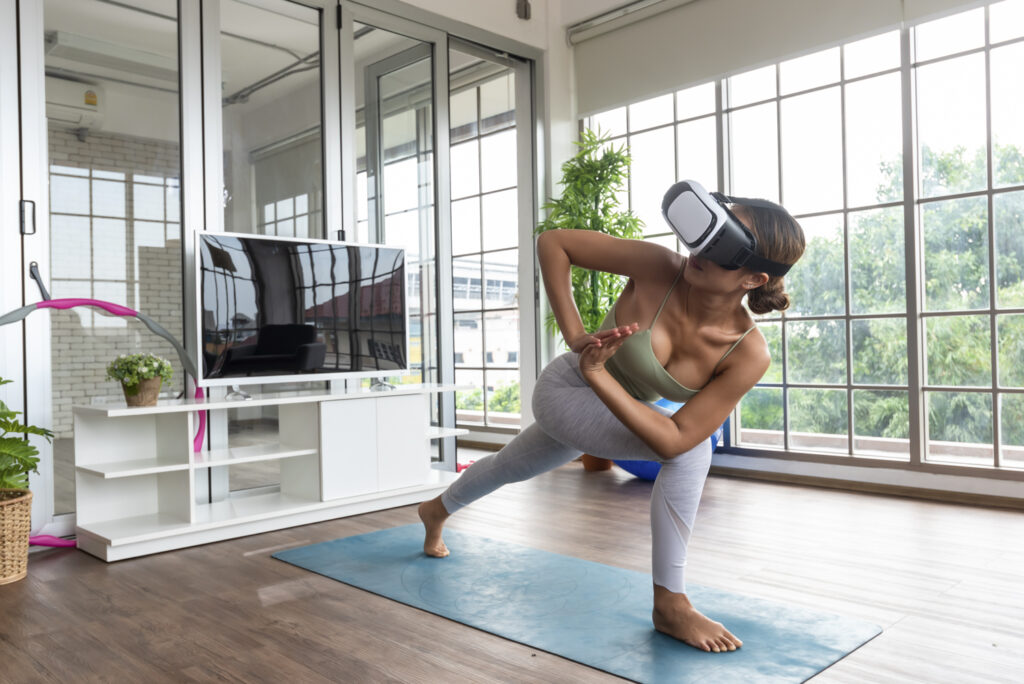 En kvinna gör yoga med VR i ett stort rum