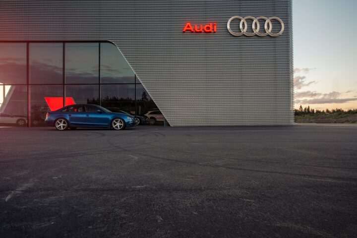 blue porsche 911 parked beside white wall